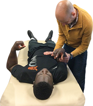 Zac Cupples testing an athlete's shoulder range of motion on a treatment table