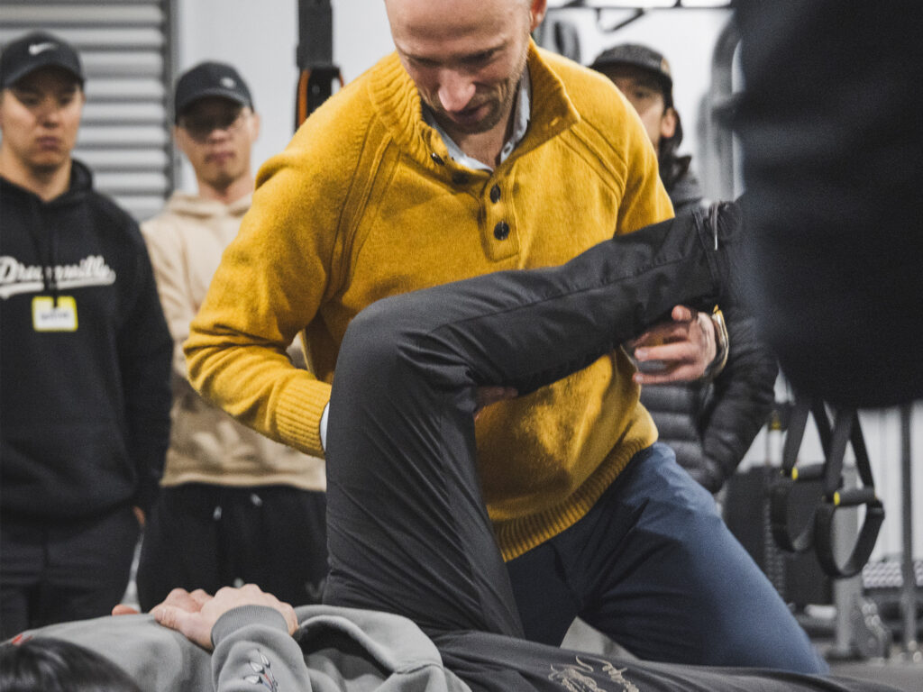 Zac Cupples performing a hip range of motion test in front of a seminar crowd